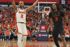 During the ACC conference basketball game between Syracuse University and Miami University, Syracuse guard J.J. STARLING (2) celebrates making his three-point shot while Miami guard CHRISTIAN WATSON (3) shows his disappointment during the first half of the game held at the JMA Wireless Dome on the campus of Syracuse University.