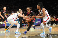 NEW YORK — DECEMBER 7: Louisville Cardinals Guard Jayda Curry (30) drives the ball between UConn Huskies Guard Paige Bueckers (5) and UConn Huskies Forward Sarah Strong (21) during the first half at the Barclays Center on December 7, 2024, in New York, New York. (Gregory Fisher/A Lot of Sports Talk)