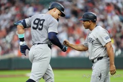 BALTIMORE — JULY 12: New York Yankees third base coach Luis Rojas (67) fists bumps New York Yankees center fielder Aaron Judge (99) for hitting a home run as he round the bases against the Baltimore Orioles during the third inning inside Oriole Park at Camden Yards on July 12, 2024, in Baltimore, Maryland. (Gregory Fisher/A Lot of Sports Talk)